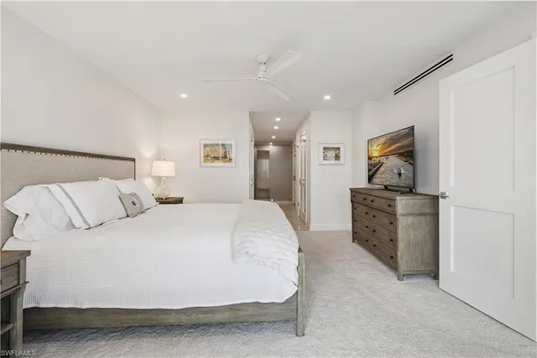 a spacious bedroom with a bed and a flat screen tv