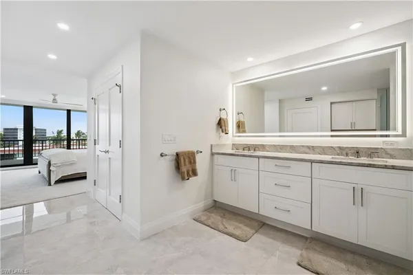 a spacious en suite bathroom with a double vanity sink and mirror