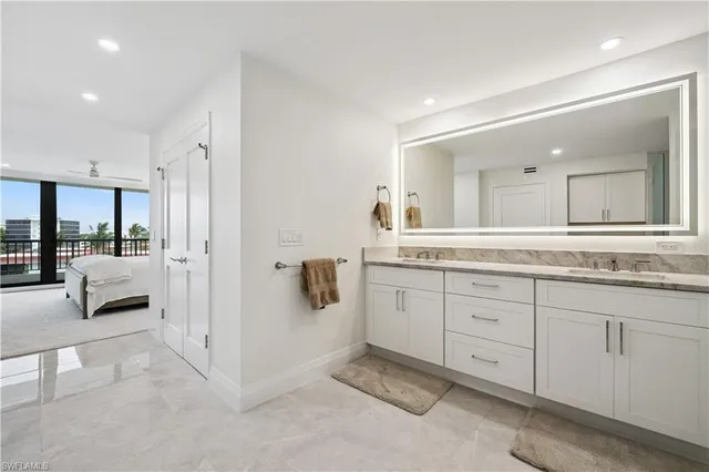 a spacious en suite bathroom with a double vanity sink and mirror