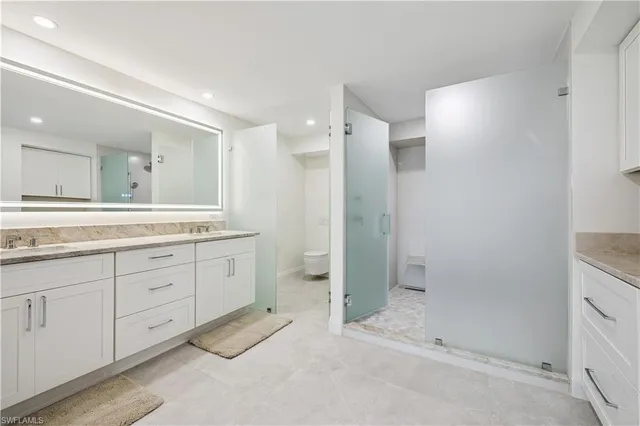 a spacious bathroom with a shower sink and mirror