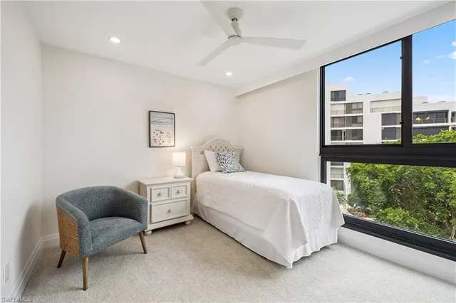 a bedroom with a bed and a large window