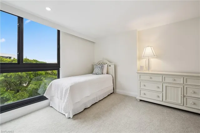 a spacious bedroom with a bed lamp and window