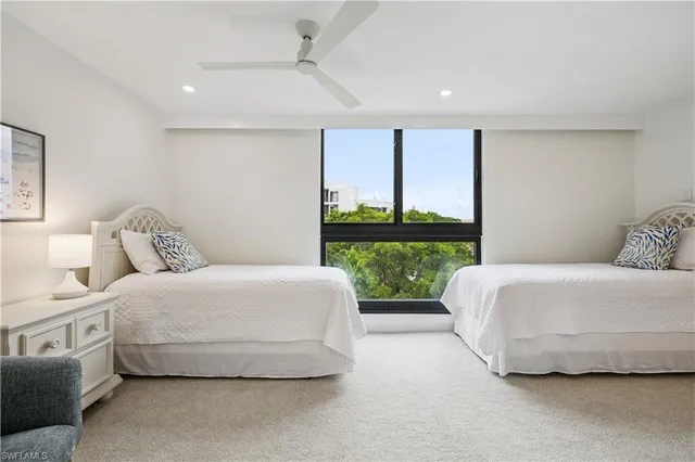 a spacious bedroom with a bed lamp and large window