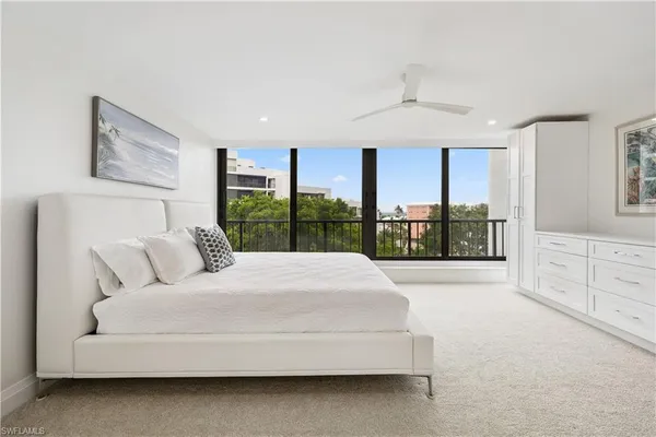 a spacious bedroom with a large bed and a large window