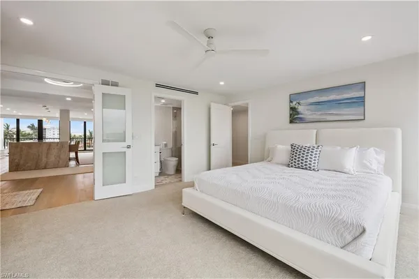 a spacious bedroom with a bed and a large mirror