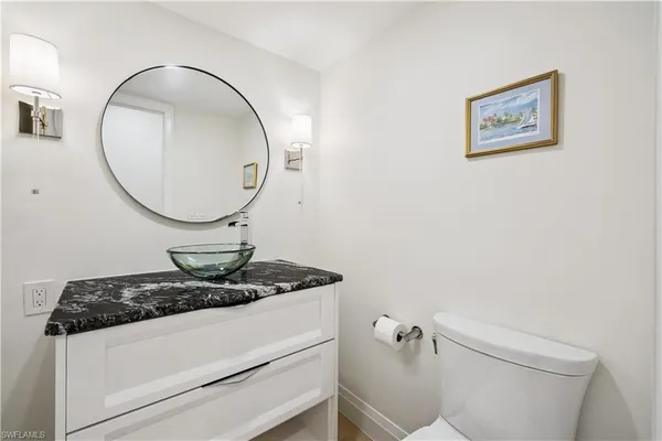 a bathroom with a granite countertop toilet and a mirror