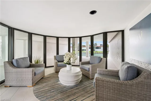 a living room with furniture and a floor to ceiling window