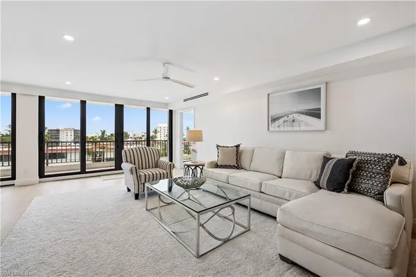 a living room with furniture and large windows