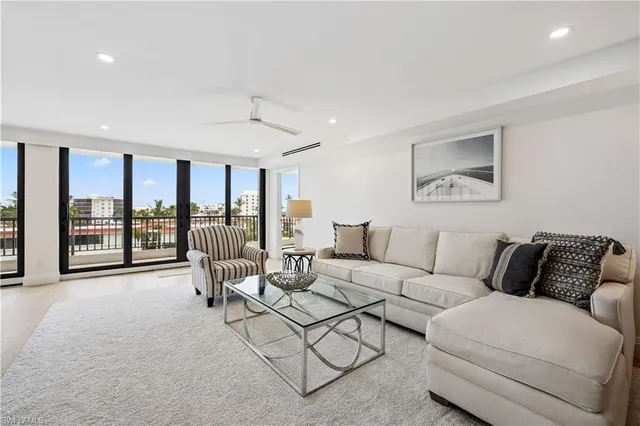 a living room with furniture and large windows