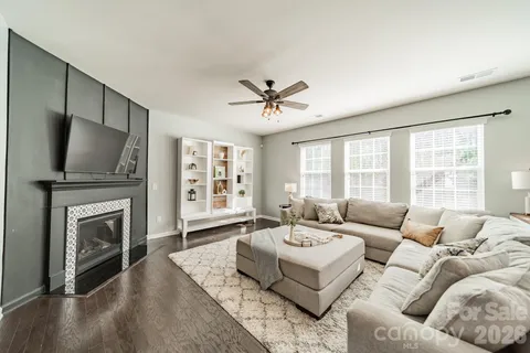 a living room with furniture a fireplace and a flat screen tv