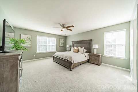 a spacious bedroom with a bed and a flat screen tv