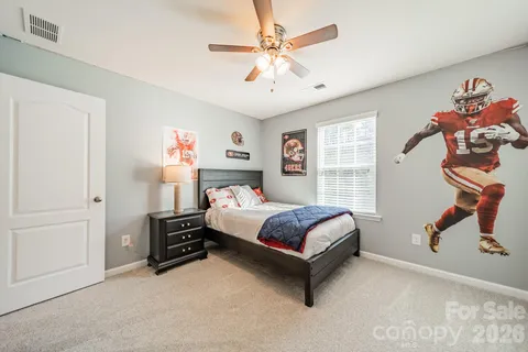 a spacious bedroom with a bed and a chandelier