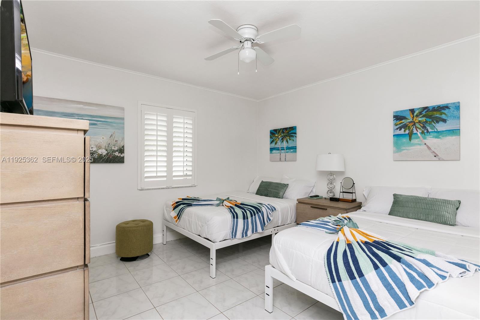 1900 North Victoria Park Road Fort Lauderdale, FL 33305 - Photo 23 of 60 a bedroom with two beds and a chandelier