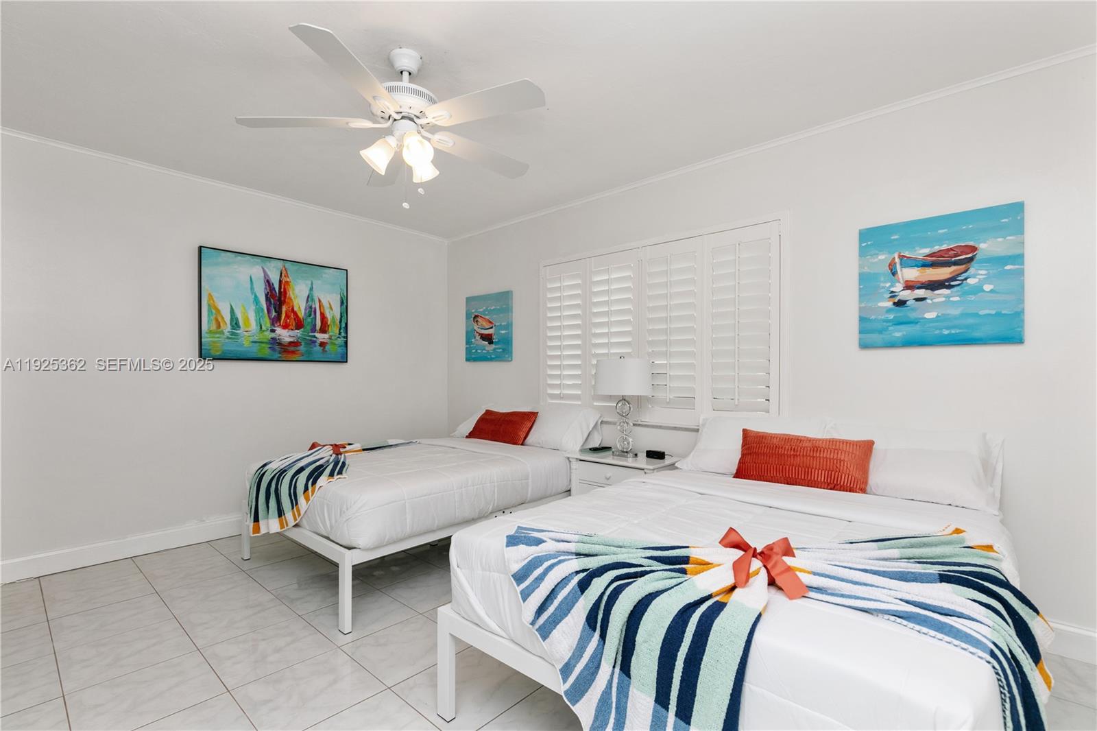 1900 North Victoria Park Road Fort Lauderdale, FL 33305 - Photo 32 of 60 a bedroom with two beds and a chandelier