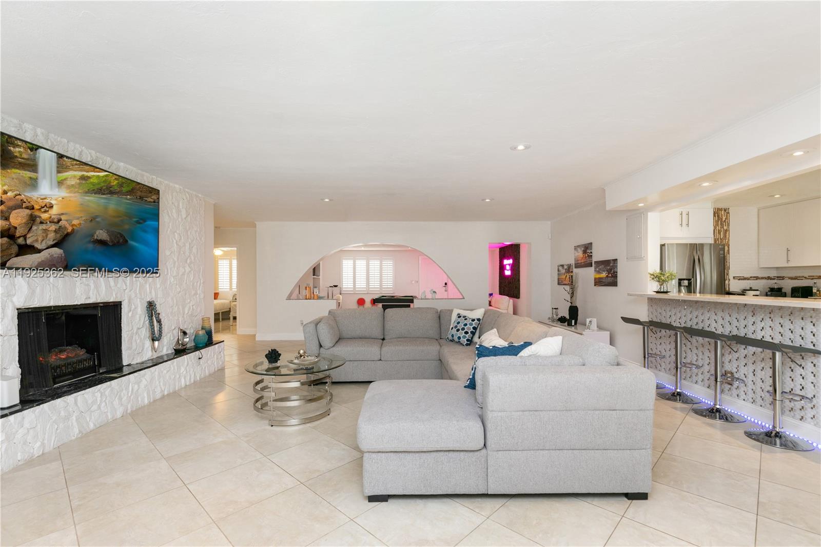 1900 North Victoria Park Road Fort Lauderdale, FL 33305 - Photo 4 of 60 a living room with furniture a fireplace and a flat screen tv