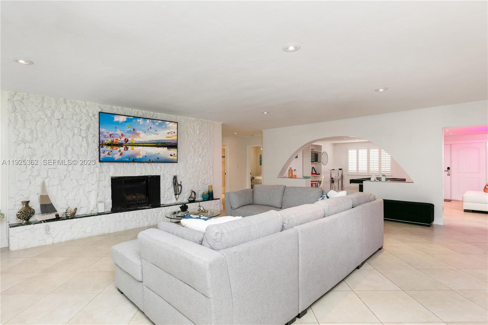 1900 North Victoria Park Road Fort Lauderdale, FL 33305 - Photo 5 of 60 a living room with furniture a fireplace and a flat screen tv