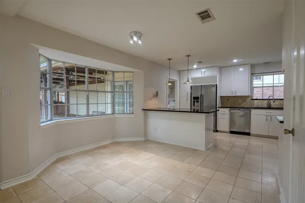 a large white kitchen with a sink and cabinets