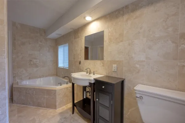 a bathroom with a sink a toilet and bathtub