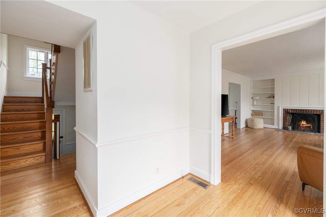5217 Sylvan Road Richmond, VA 23225 - Photo 8 of 46 a view of a hallway with wooden floor and a fireplace