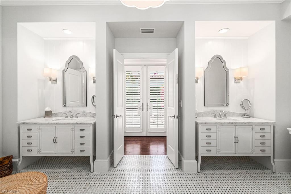 16755 Lucarno Way Naples, FL 34110 - Photo 17 of 50 a en suite bathroom with a double vanity sink and a mirror