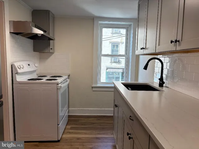 a kitchen with stainless steel appliances granite countertop a sink a stove and wooden floor