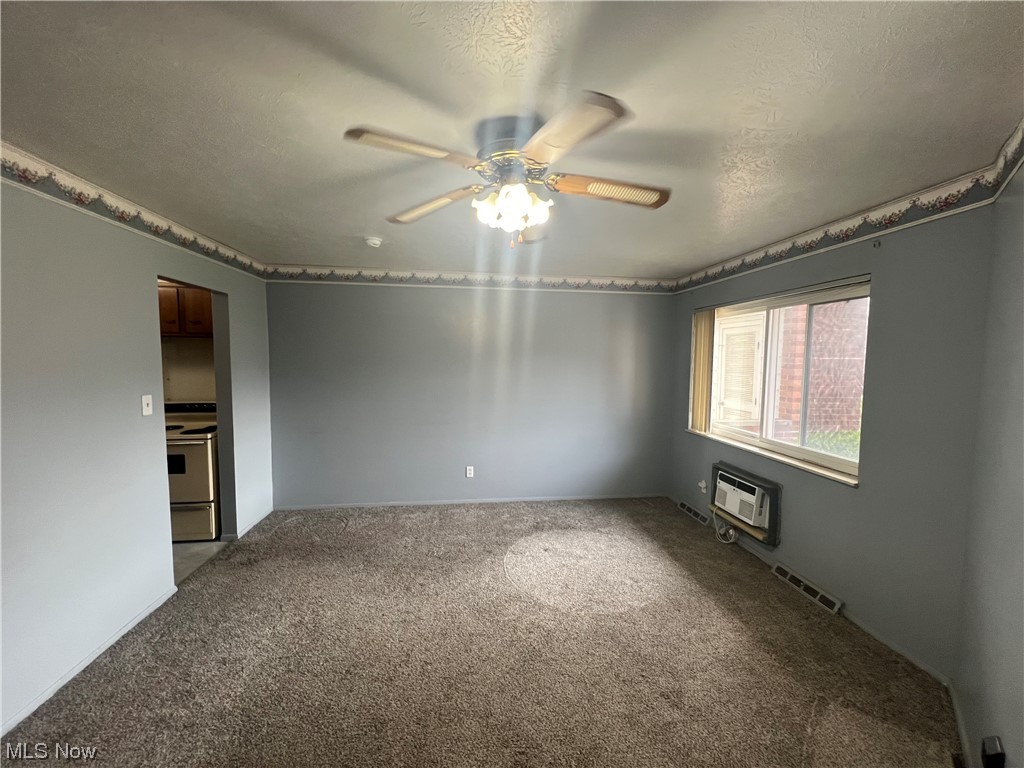 5651 Broadview Road, Unit C 07 Cleveland, OH 44134 - Photo 4 of 15 Spare room featuring a textured ceiling, carpet, an AC wall unit, and ceiling fan