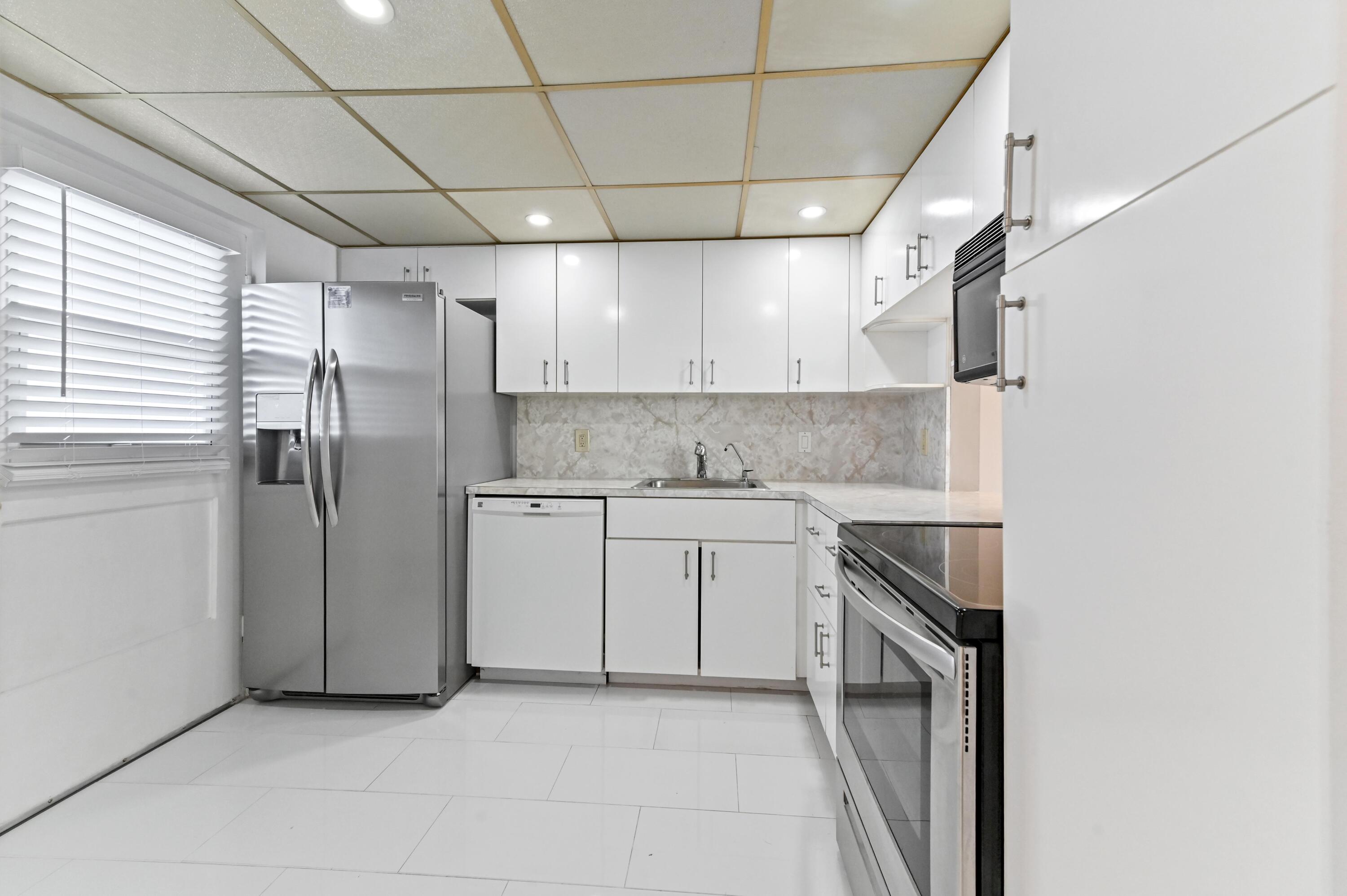 5700 Northwest 2nd Avenue, Unit 503 Boca Raton, FL 33487 - Photo 11 of 37 a kitchen with a stove a sink and refrigerator