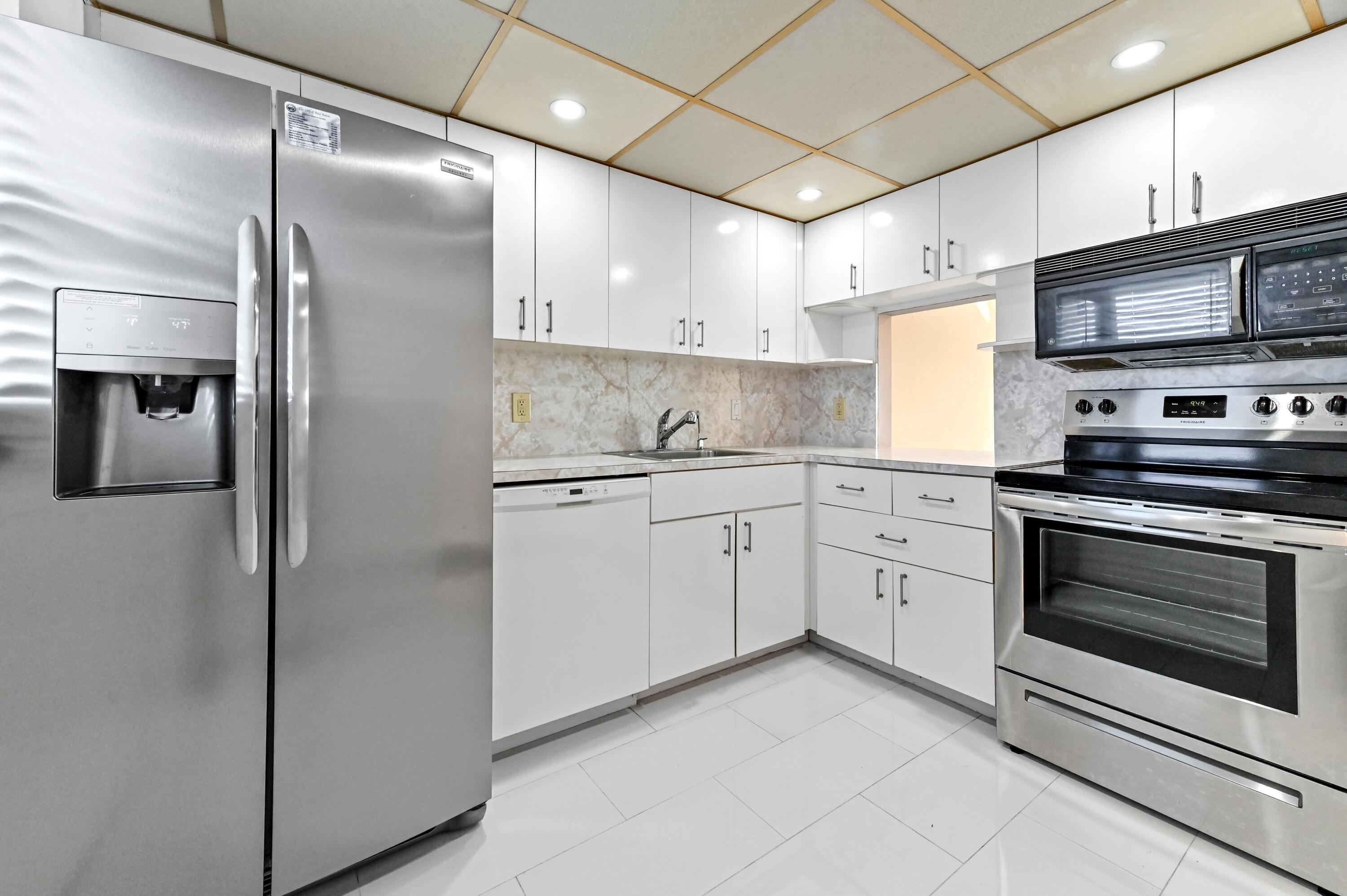 5700 Northwest 2nd Avenue, Unit 503 Boca Raton, FL 33487 - Photo 12 of 37 a kitchen with stainless steel appliances a refrigerator sink and microwave