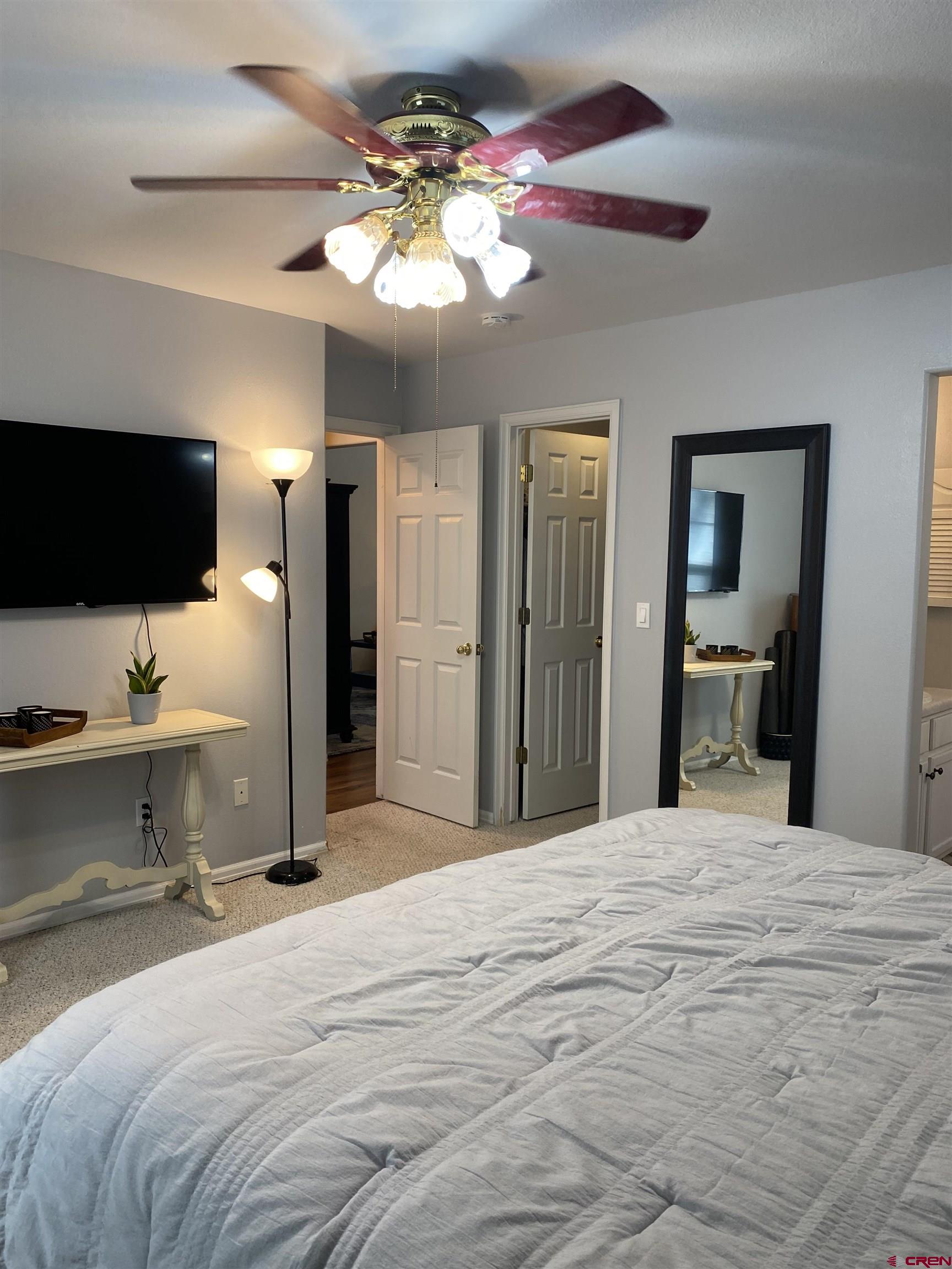 802 Riley Lane Delta, CO 81416 - Photo 11 of 16 a bedroom with a bed and a flat screen tv