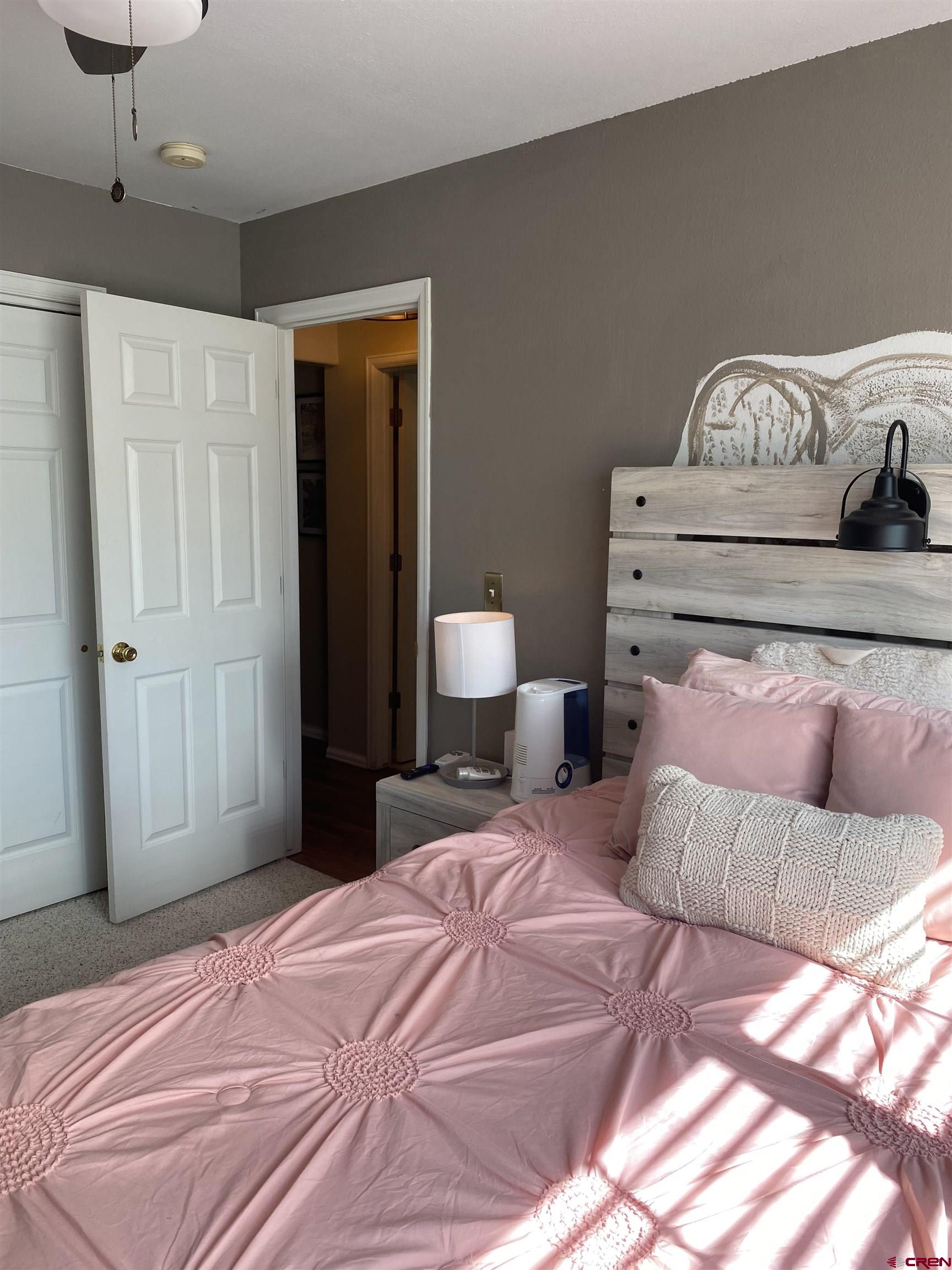 802 Riley Lane Delta, CO 81416 - Photo 13 of 16 a bedroom with a bed and a lamp