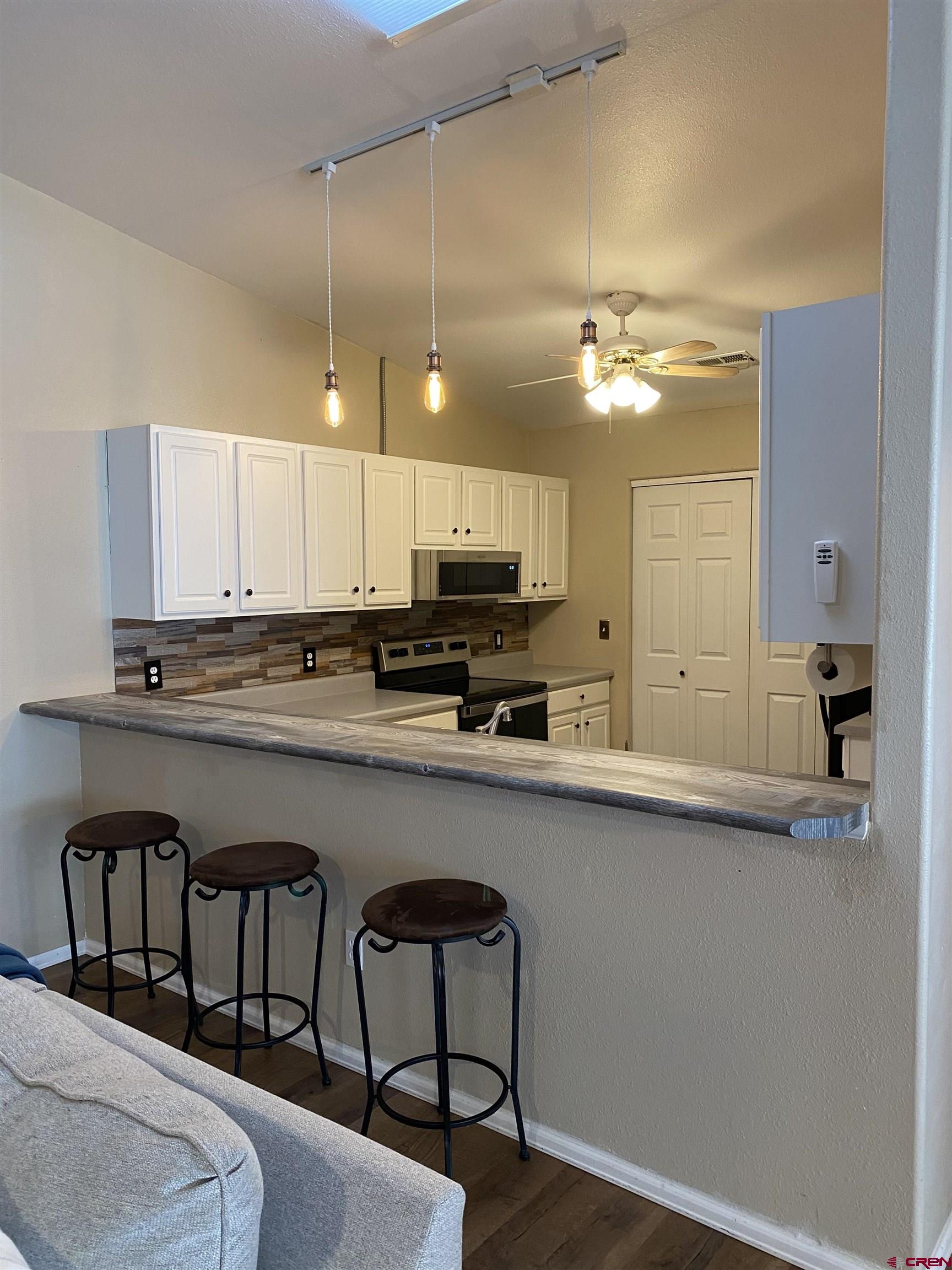 802 Riley Lane Delta, CO 81416 - Photo 7 of 16 a kitchen with stainless steel appliances granite countertop a sink a stove a refrigerator cabinets and living room view