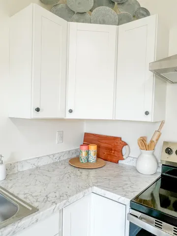 a kitchen with stainless steel appliances granite countertop a sink and a white cabinets