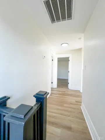 a view of a livingroom with wooden floor and a staircase