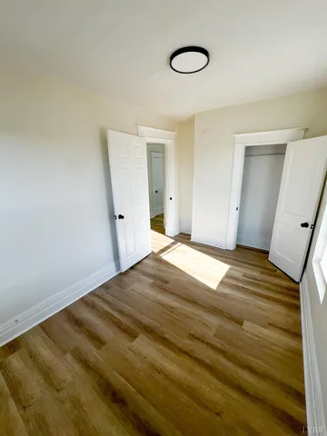 a view of a room with wooden floor and white walls