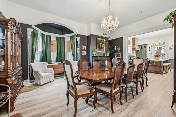 a dining room with furniture a chandelier and wooden floor