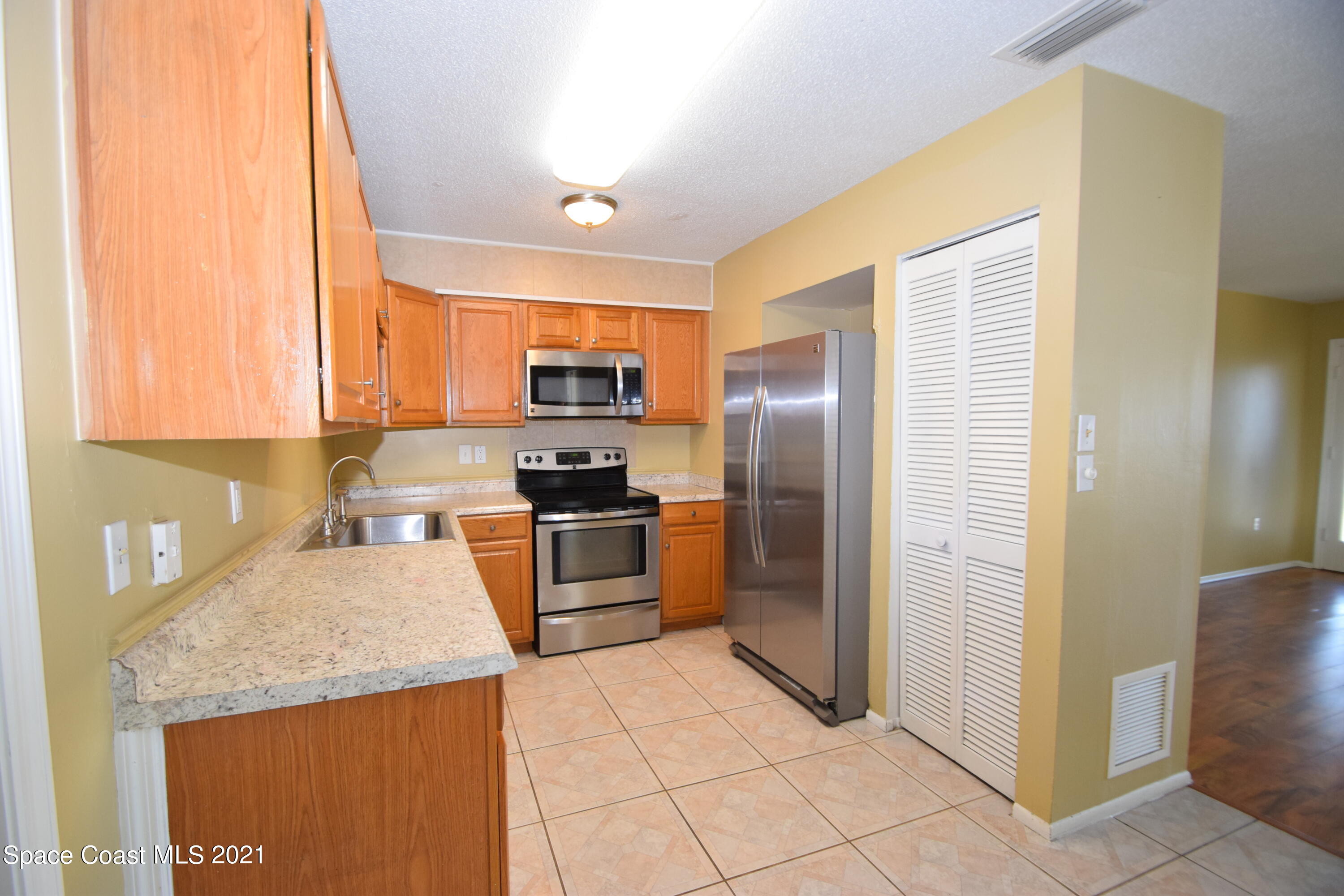 680 Aloha Avenue Cocoa, FL 32927 - Photo 11 of 27 a kitchen with granite countertop a refrigerator and a stove top oven
