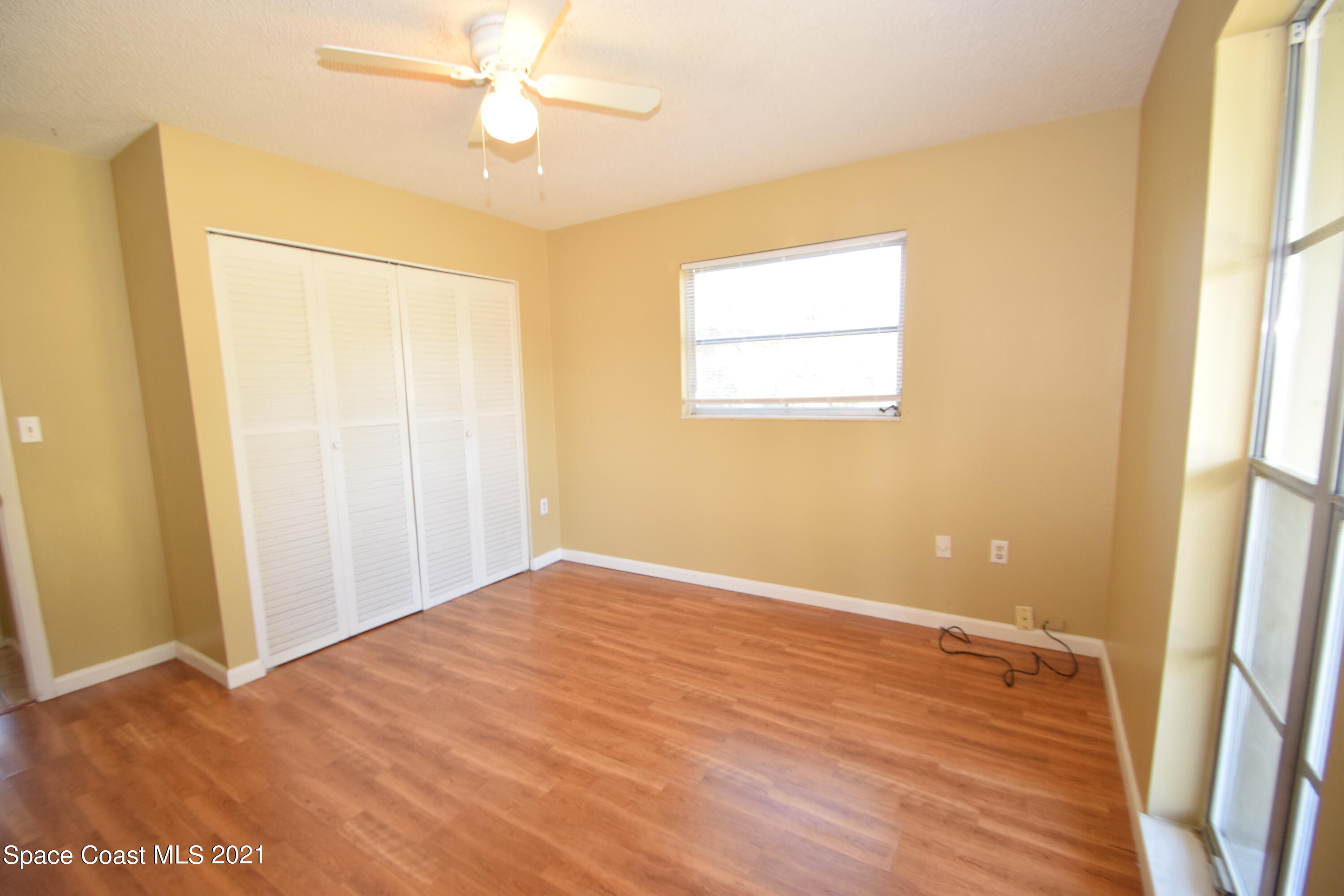 680 Aloha Avenue Cocoa, FL 32927 - Photo 17 of 27 a view of an empty room with wooden floor and a window