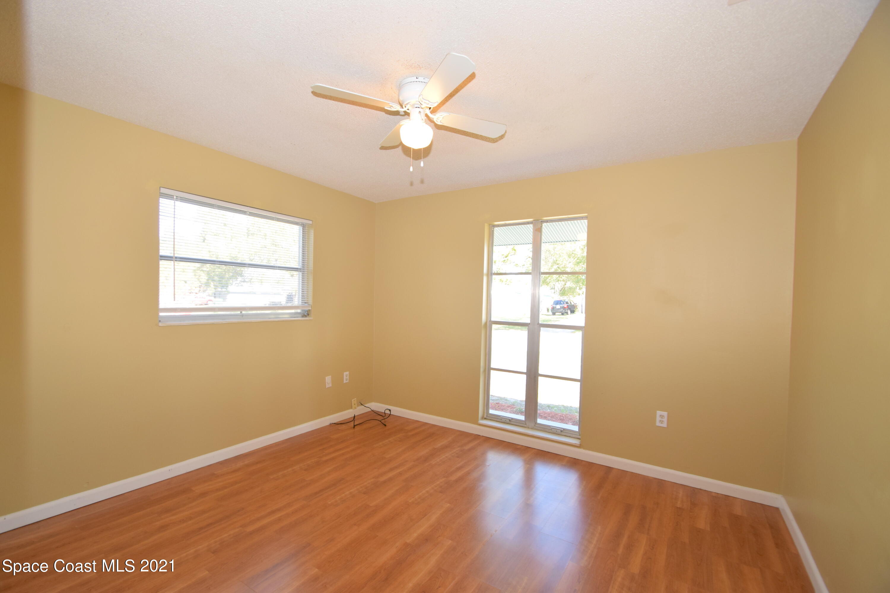 680 Aloha Avenue Cocoa, FL 32927 - Photo 18 of 27 a view of empty room with wooden floor and fan