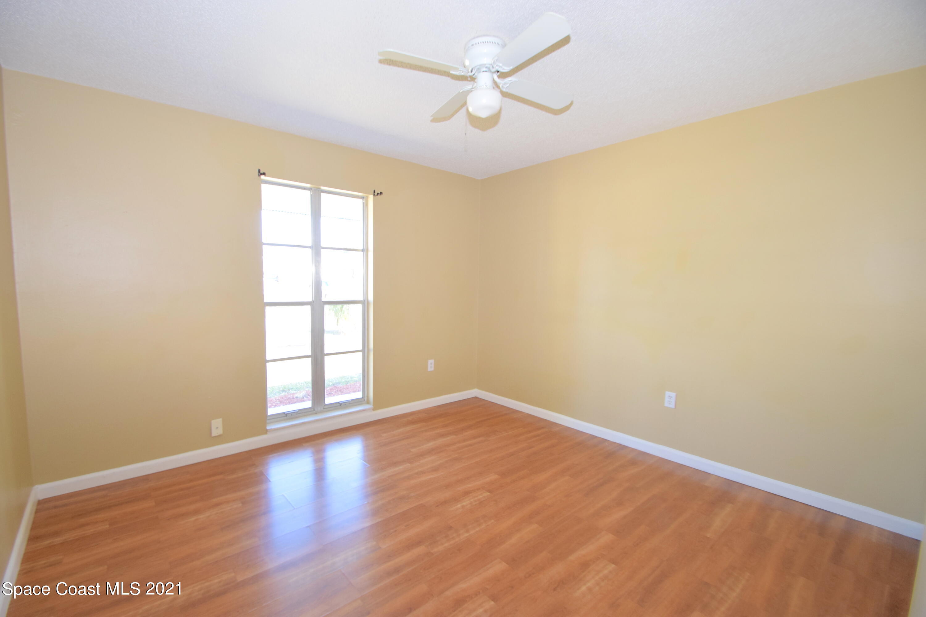 680 Aloha Avenue Cocoa, FL 32927 - Photo 19 of 27 an empty room with wooden floor and windows