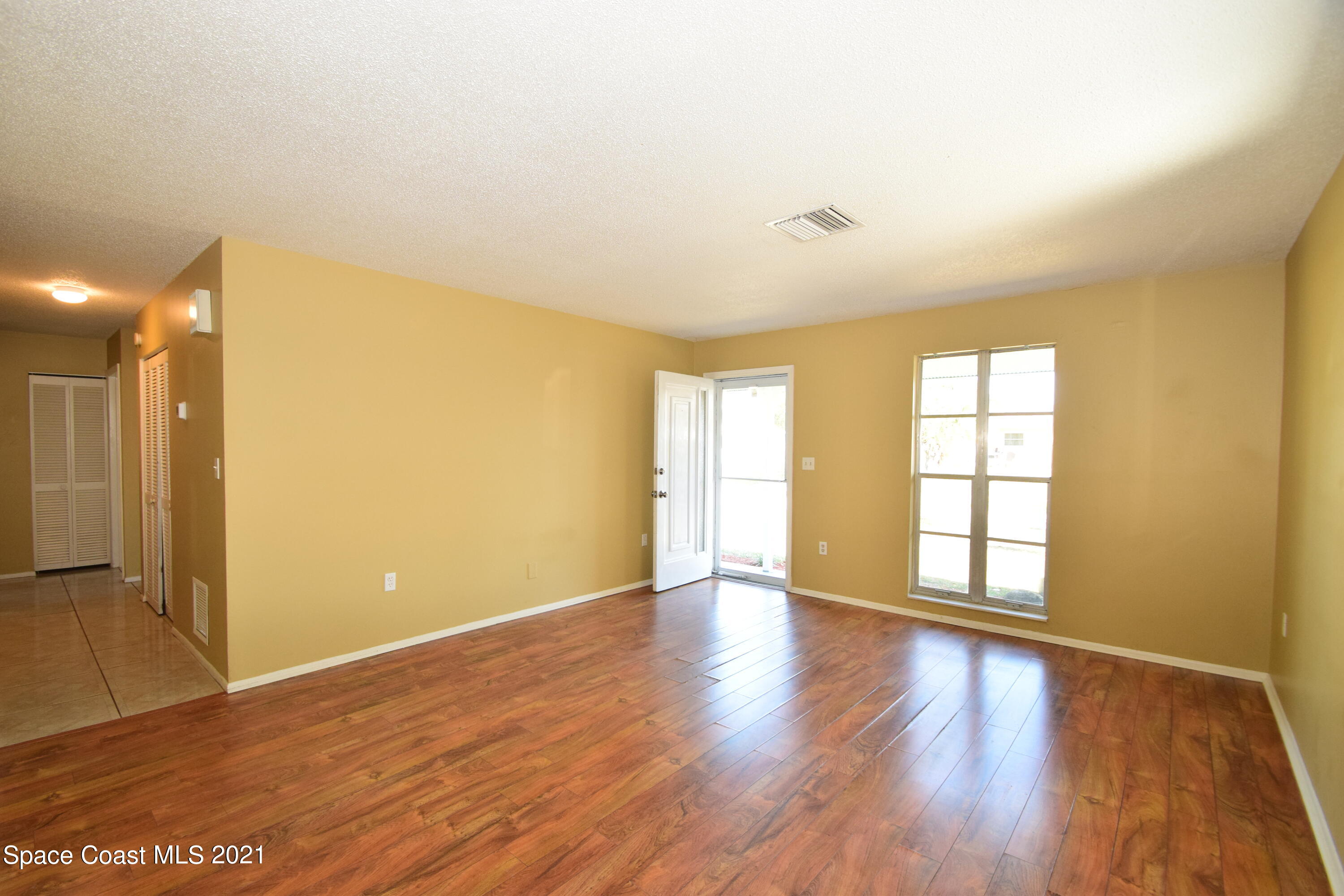 680 Aloha Avenue Cocoa, FL 32927 - Photo 7 of 27 an empty room with wooden floor and windows