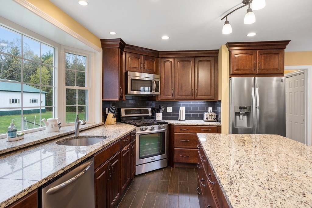 85 Forest Street Dunstable, MA 01827 - Photo 9 of 42 a kitchen with stainless steel appliances granite countertop sink stove refrigerator and cabinets