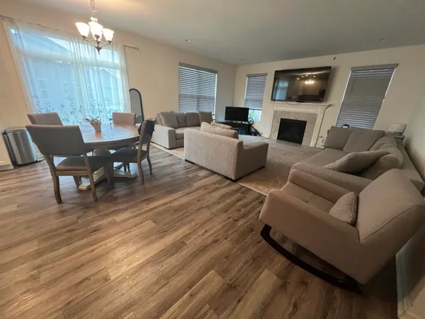 a living room with furniture a fireplace a flat screen tv and kitchen view
