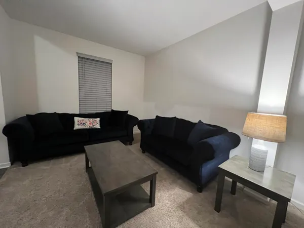 a living room with furniture and a lamp