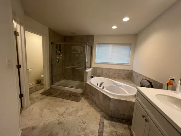 a bathroom with a tub a sink and a shower
