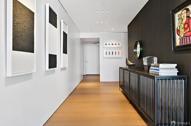 a view of a hallway with wooden floor and windows