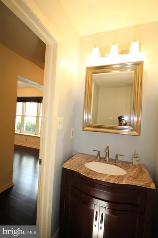 a bathroom with a granite countertop sink a toilet and a mirror