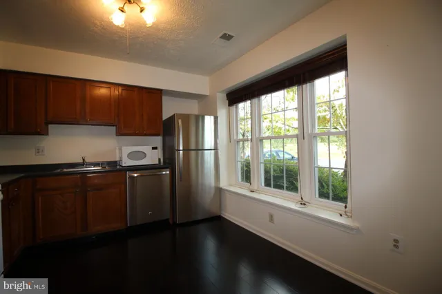 a kitchen with stainless steel appliances wooden cabinets and a refrigerator