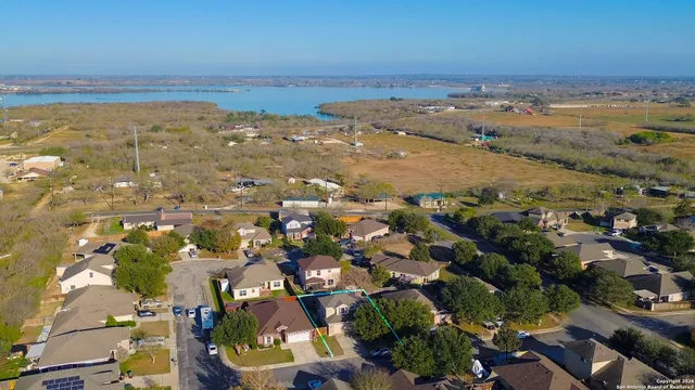 an aerial view of ocean and residential houses with outdoor space