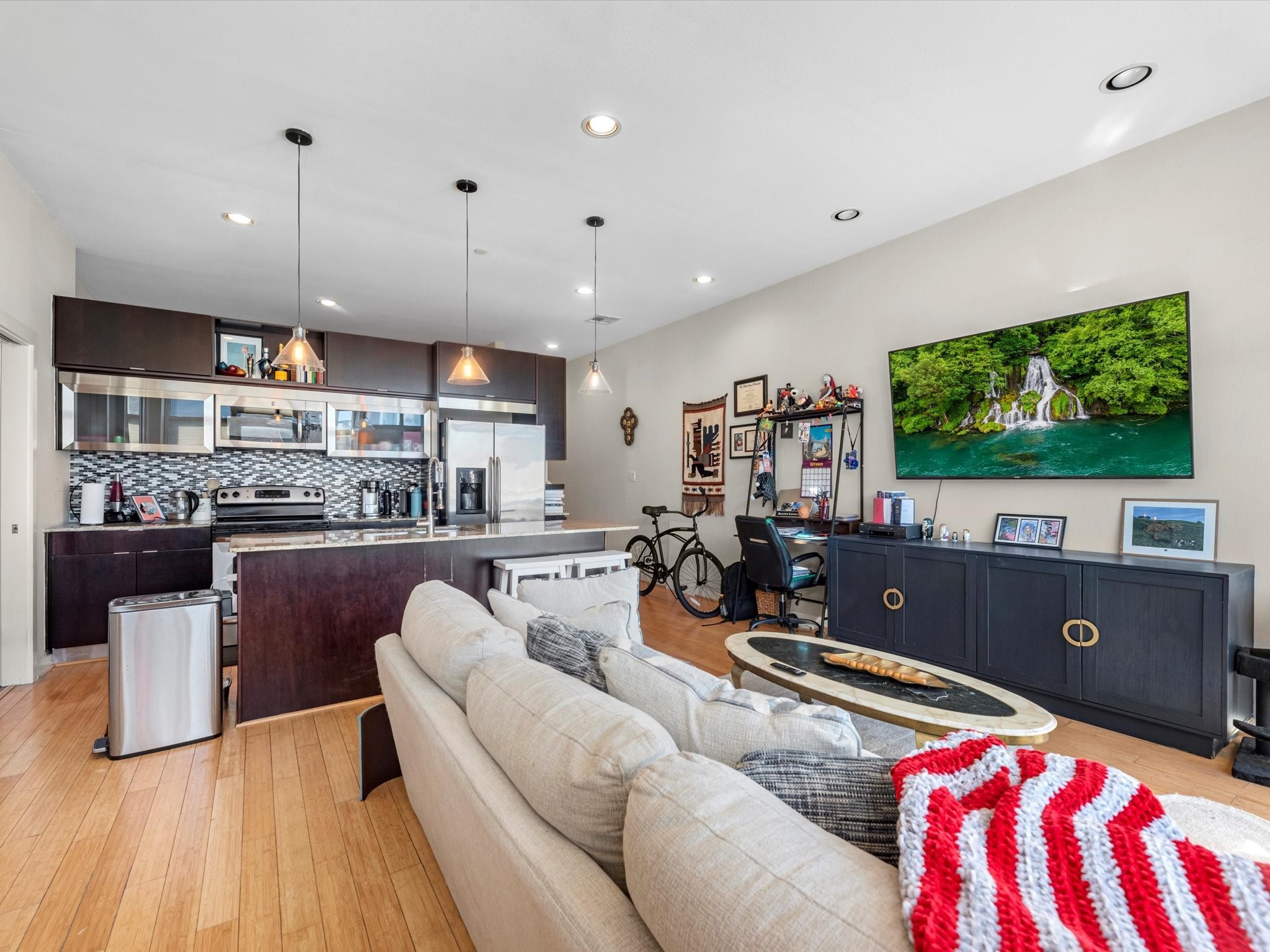 1406 Columbus Street, Unit 303 Houston, TX 77019 - Photo 5 of 17 a living room with kitchen island furniture and a flat screen tv