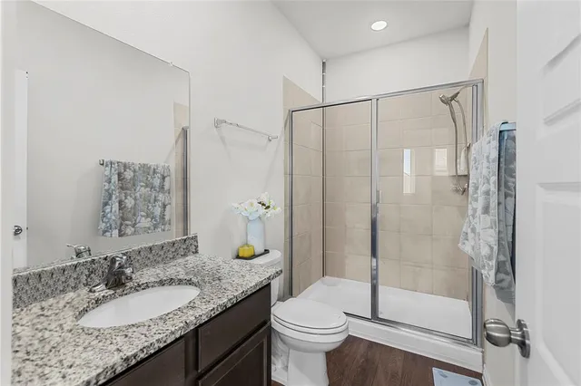 a bathroom with a granite countertop sink toilet and shower